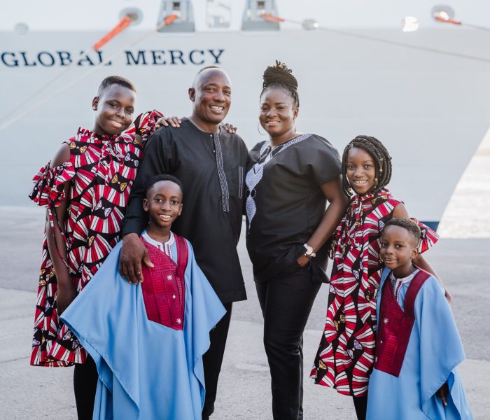 Lawrence and Janet Adjei and their children in front of the Global Mercy.