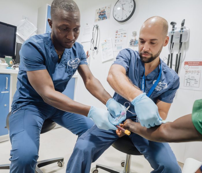 Trent Yoder, Preoperative Nurse, and Solomon Santigie KARGBO, Day Crew, during a patient consultation.